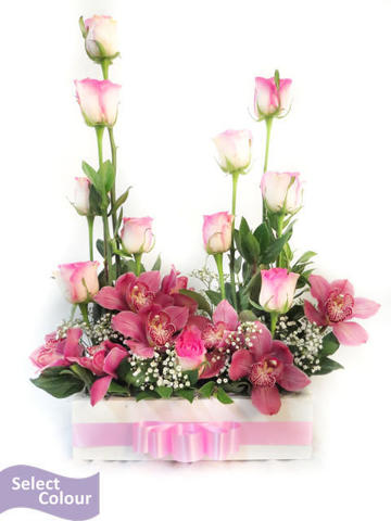 Arrangement of roses and orchids in wooden box
