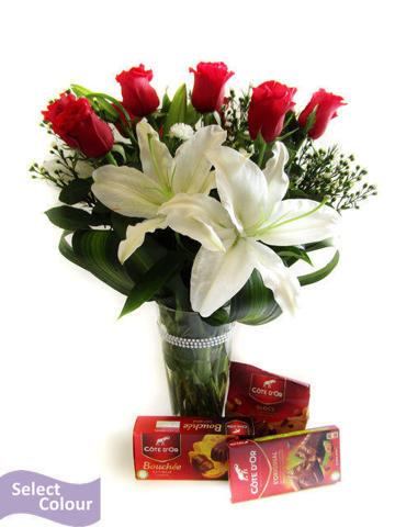Roses and lilies in vase with chocolates